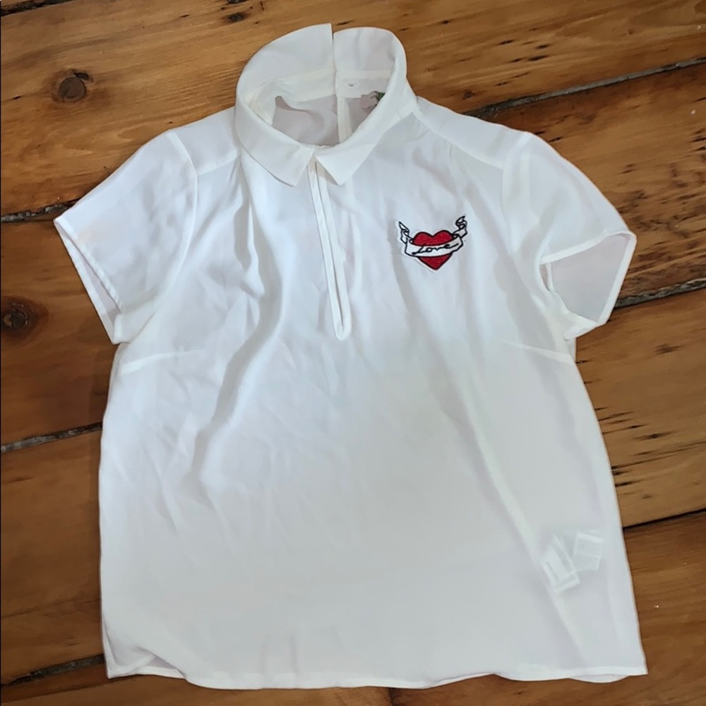 White collared shirt with “love” patch.